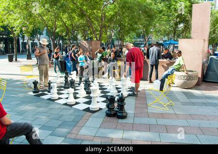 Seattle, WA USA 23. August 2014: Die Menschen genießen das riesige Outdoor-Schachspiel im Occidental Park auf dem Pioneer Square in diesem städtischen Stadtbild in Seattle. Stockfoto