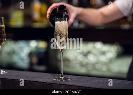 Nahaufnahme eines Glases Champagner aus einer Flasche. Stockfoto