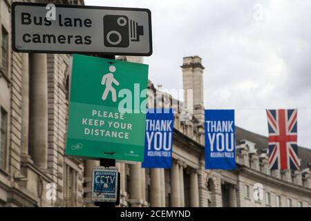 London, Großbritannien. August 2020. Ein 'Please Keep Your Distance' Poster wird während der Coronavirus-Pandemie auf der Regents Street ausgestellt.Es ist obligatorisch, Gesichtsmasken während der Reise zu tragen. Kredit: SOPA Images Limited/Alamy Live Nachrichten Stockfoto