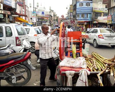 AMRITSAR, INDIEN - 18. MÄRZ 2019: Blick auf einen Zuckerrohrsaft-Verkäufer und Kunden in amritsar Stockfoto