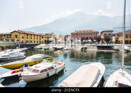 Comer See. Italien - 21. Juli 2019: Segelboote und Boote im kleinen Hafen von Colico City. Comer See in Italien. Hotels und Gebäude am Ufer des Comer Sees Stockfoto