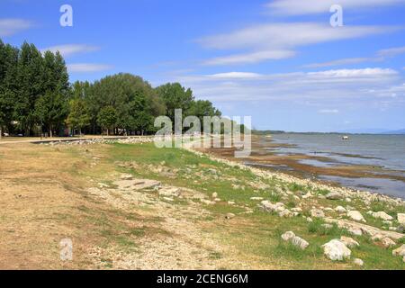 Die Ufer des Trasimenischen Sees sehr berühmt in Umbrien und der größte See in Mittelitalien. Wird im Sommer zum Baden und für Familienausflüge verwendet. Stockfoto