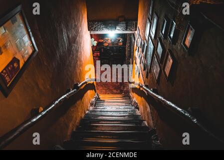 Dramatische Sicht auf die unheimlich Treppen von oben in die Dunkelheit des Inneren des alten Pubs Stockfoto