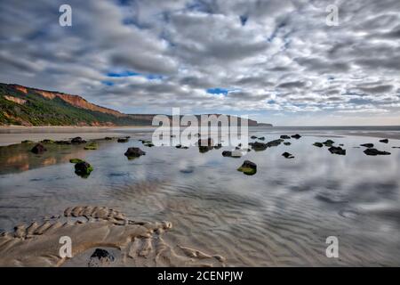 Wolken spiegeln sich im ruhigen Wasser im Felsenpool am Addiscott Beach, in der Nähe von Anglesea, Great Ocean Road, Victoria, Australien Stockfoto