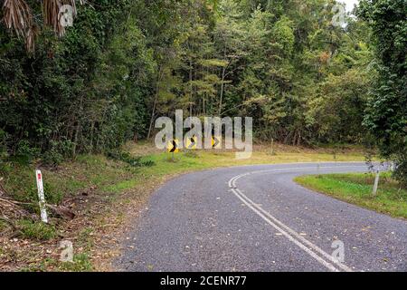 Pfeilschilder, die Reisenden eine enge Kurve anzeigen Auf der Straße vor uns Stockfoto