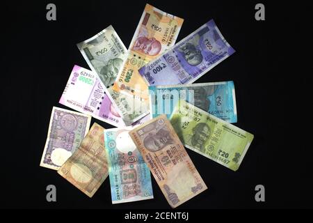 Jetzt und alte indische Währungen. 50, 100, 200, 500, 2000 Rupien-Scheine und Münzen. Indische Währung auf schwarzem Hintergrund isoliert. Stockfoto