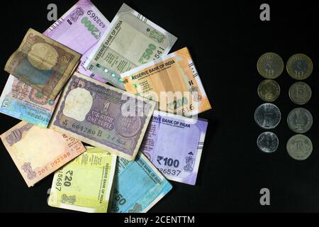 Jetzt und alte indische Währungen. 50, 100, 200, 500 Rupien-Scheine und Münzen. Indische Währung auf schwarzem Hintergrund isoliert. Stockfoto