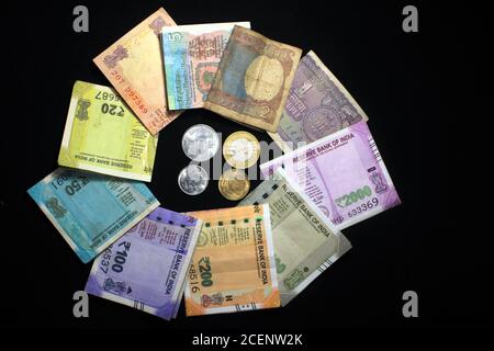 Jetzt und alte indische Währungen. 50, 100, 200, 500 Rupien-Scheine und Münzen. Indische Währung auf schwarzem Hintergrund isoliert. Stockfoto