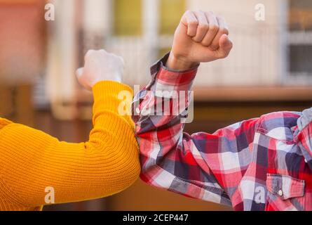 Schütteln Sie nicht die Hände. Stoppen Sie Handshakes. Ellenbogenstoß. Beule Ellbogen. Freunde schütteln Ellbogen im Freien. Grußformel mit Ellenbogen. Coronavirus-Epidemie Stockfoto