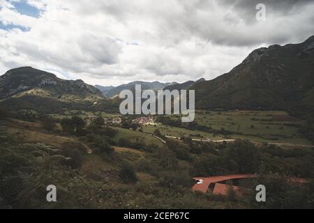 Luftaufnahme eines Dorfes in einem Tal an einem bewölkten Tag in Soto de Agues, Asturien, Spanien Stockfoto