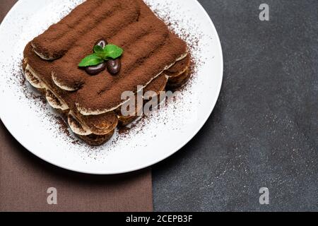 Klassisches Tiramisu Dessert auf Keramikplatte auf Betongrund Stockfoto
