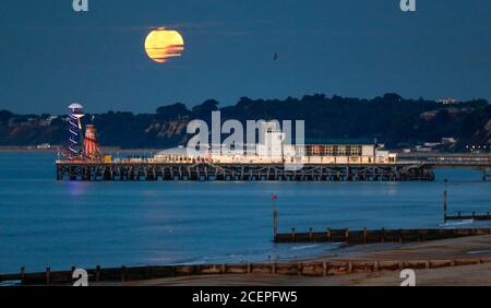 Bournemouth, Großbritannien. September 2020. Der September-Vollmond, manchmal auch als Maismond bezeichnet, setzt über Bournemouth Pier in Dorset. Quelle: Richard Crease/Alamy Live News Stockfoto