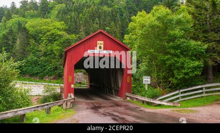 Point Wolfe Covered Bridge – eine berühmte, rot bemalte Holzbrücke in der Nähe von Alma im Fundy National Park, New Brunswick, Kanada Stockfoto