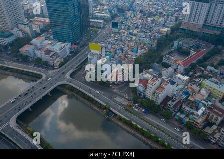 Weitwinkel Drohne Blick auf Ben Nghe Kanal mit Saigon, Vietnam City Skyline, Calmette Brücke und nebligen Morgen Tag Zeit Verkehr Stockfoto