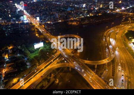 Weitwinkel serielle Ansicht der Autobahn Interchange Offramp und Brücke über Kanal mit Verkehr. Städtische Zersiedelung ist in thee Hintergrund Stockfoto