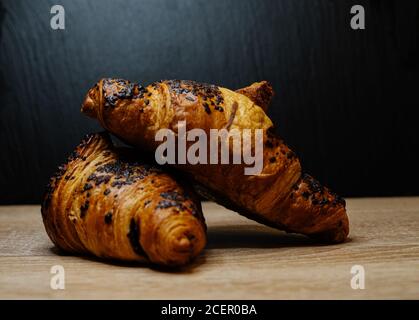 Nahaufnahme von frischen Croissants auf einer Holzoberfläche - Perfekt für den Hintergrund Stockfoto