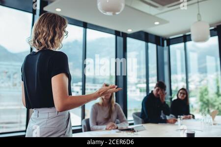 Geschäftsfrau, die eine Präsentation vor ihren Kollegen im Büro macht. Weibliche Unternehmerin, die eine Präsentation bei der Arbeit. Stockfoto