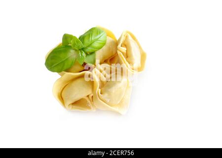 Rohe frische Tortellini Pasta mit Basilikumblättern isoliert auf weiß Hintergrund Stockfoto