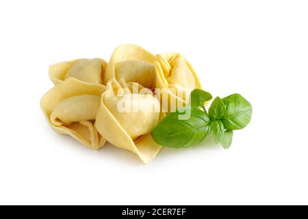 Rohe frische Tortellini Pasta mit Basilikumblättern isoliert auf weiß Hintergrund Stockfoto