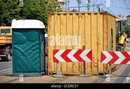Frachttransport Container und eine tragbare Toilette auf der Straße Stockfoto