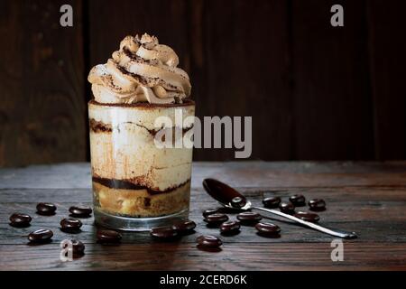 Italienische Dessert Tiramisu in einem Glas auf einem hölzernen Hintergrund Stockfoto