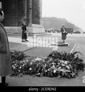 1950er Jahre, historisch, Paris, Frankreich, eine Dame unter dem Arc de Triomphe, Lesung der Gedenkstätte geschrieben, "Ici Repose UN Soldat Francais Mort Pour La Patrie 1914-1945", das Grab des unbekannten Soldaten aus dem 1. Weltkrieg, mit seiner ewigen Flamme. Die Gedenkstätte wurde am 1920. Tag der Armstwende errichtet. Stockfoto