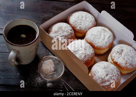 Gelee-Donuts in Papierkarton auf Holzhintergrund Stockfoto