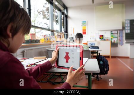 Hemmingen, Deutschland. August 2020. Ein Schüler arbeitet in einer Grundschule an einem Tablet. Quelle: Sebastian Gollnow/dpa/Alamy Live News Stockfoto