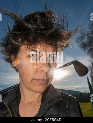 Golfer Leaning ihren Golfclub auf ihren Schultern mit Sonnenlicht. Stockfoto