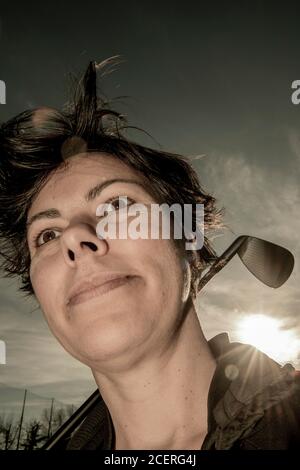 Golfer Leaning ihren Golfclub auf ihren Schultern mit Sonnenlicht. Stockfoto