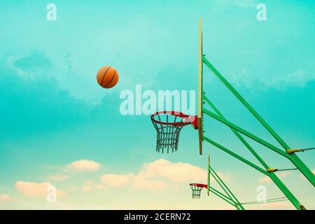 Wurfbasketball fliegt zum Kettenkorb. Stockfoto