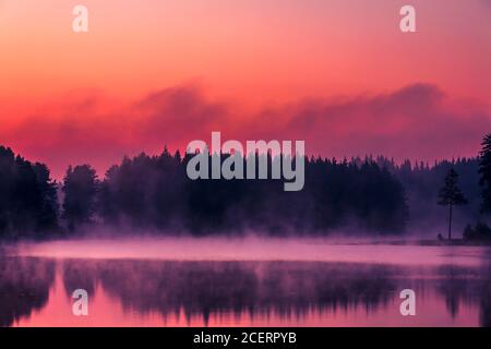 Rauch über einem wunderschönen Bergsee bei Sommeranbruch Stockfoto