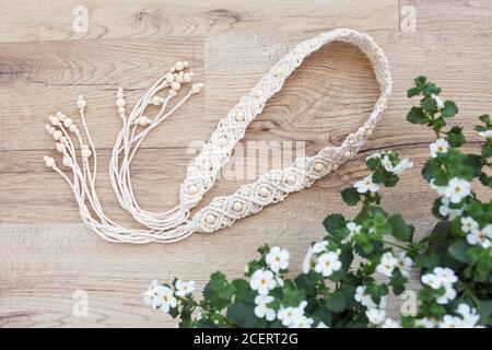 Handgefertigter Macrame-Gürtel. Naturbaumwollfäden und Holzperlen. Stilvolle Dekoration für Frauen Kleid. Mapramgeflecht und Baumwollfäden. Stockfoto