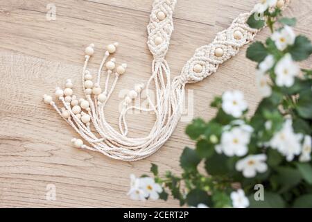 Handgefertigter Macrame-Gürtel. Naturbaumwollfäden und Holzperlen. Stilvolle Dekoration für Frauen Kleid. Mapramgeflecht und Baumwollfäden. Stockfoto