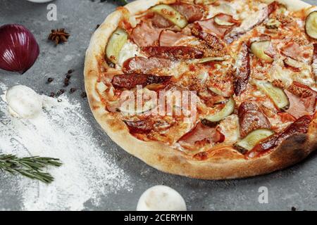 Pepperoni Pizza in Scheiben mit Salami, Würstchen und Joghurt Stockfoto