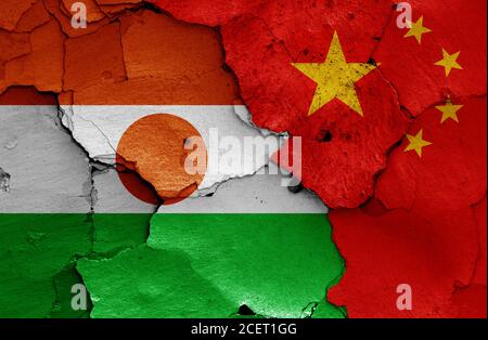 Flaggen von Niger und China auf rissige Wand gemalt Stockfoto