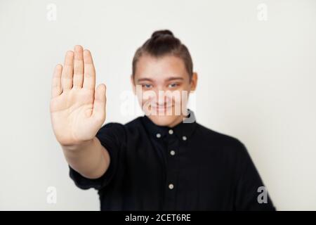 Junge Kerl Student in schwarzem Hemd stehen gegen isolierte grauen Hintergrund machen Handfläche Stop Geste. Ein Warnausdruck mit einer negativen und ernsten Geste im Gesicht Stockfoto