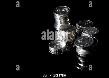 Tschechische Silbermünzen auf schwarzem Glas. Zahlung in der Tschechischen Republik. Münzen in Spalten gestapelt. Finanzielle Einsparungen. Stockfoto