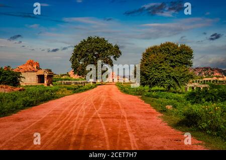 Vithala Tempel mit führenden roten Boden Straße und erstaunlichen blauen Himmel bei hampi Ruinen Bild wird in hampi karnataka indien genommen. Stockfoto