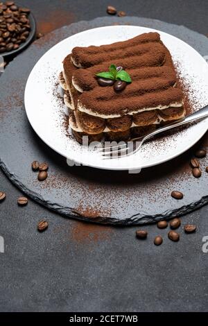 Klassisches Tiramisu Dessert auf Keramikplatte auf Betongrund Stockfoto