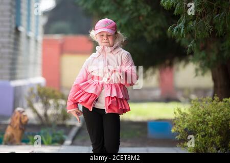 Weißrussland, die Stadt Gomil, 30. Mai 2019. Fotoshooting im Kindergarten. Ein lustiges Mädchen Vorschulkinder spielt auf einer Frühlingsstraße. Stockfoto