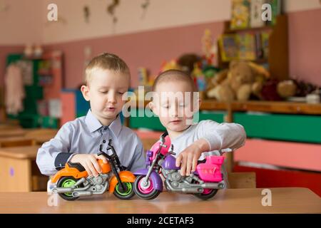 Weißrussland, die Stadt Gomil, 11. Mai 2019. Fotosession im Kindergarten. Kinder im elementaren Alter spielen. Junge und Mädchen aus dem Kindergarten mit Spielzeug vehic Stockfoto