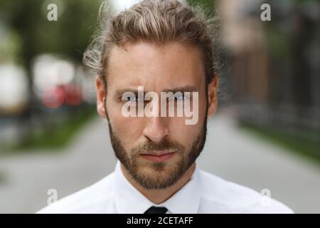 Porträt eines hübschen lockigen Mannes, in einem Business-Stil. Der schurre Look eines attraktiven Geschäftsmannes Stockfoto