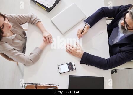 Aus der obigen Ansicht Aufnahme des professionellen Psychotherapeuten, der mit der Arbeit beginnt Junge Frau, die vor ihm sitzt Stockfoto
