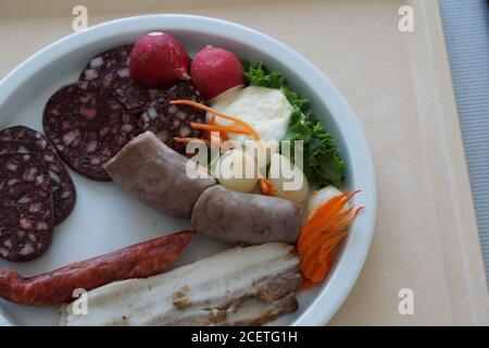 High-Angle-Aufnahme einer Mahlzeit auf einem weißen Teller Von verschiedenen Sorten von Würstchen und Speck Stockfoto