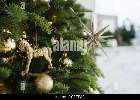 Weihnachten Spielzeug Pferd und Bälle hängen auf dem Baum, mit Lichtern geschmückt. Speicherplatz kopieren Stockfoto