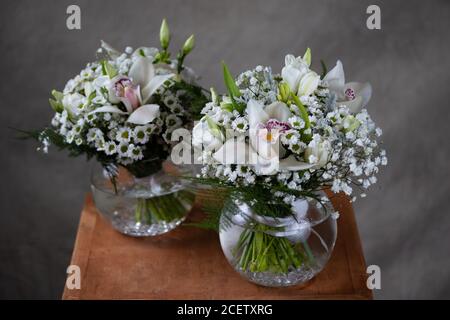 Erste heilige Kommunion Blumensträuße. Dekoriert mit Orchidee und Blumen weißen Blumen. Grauer Hintergrund Stockfoto