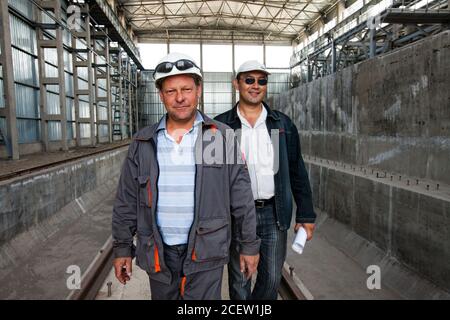 Taraz/Kasachstan - April 25 2012: Phosphordüngeanlage. Zwei Ingenieure im neuen Fabrikgebäude. Stockfoto