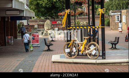 Ein Fahrrad mit Gold gesprüht wird in der Mitte einer Fußgängerzone zur Erinnerung an die Kindheit Krebs Bewusstsein Monat angezeigt. Stockfoto