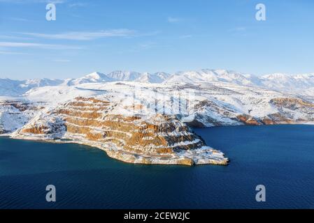 Erstaunliche Winterlandschaft des Charvak Stausees mit blauem Wasser in Usbekistan an einem Wintertag. Touristenkarte des Landes Stockfoto